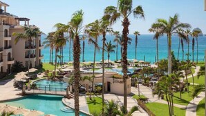 Ein Resort mit Pool, Palmen und Meerblick.
