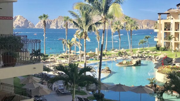 Ein Resort mit Pool, Palmen und Meerblick.