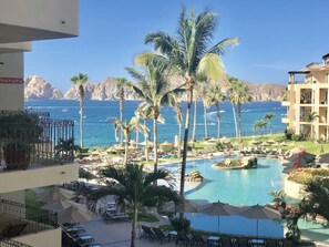 Un resort con piscina, palmeras y vistas al océano.