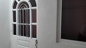 Une porte blanche avec une fenêtre et un portail en métal.