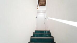 A staircase with green steps leading to a white door. - House in the heart of Naples: comfort, style and perfect location (Napoli)