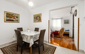 Uma sala de jantar com mesa, cadeiras e obras de arte nas paredes.