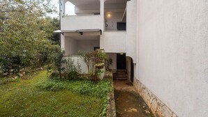 A two-story building with a covered outdoor area and a small garden.