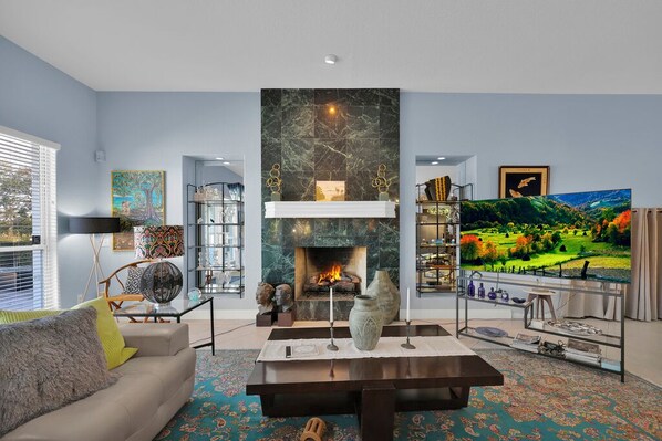 Una sala de estar moderna con chimenea, un sofá, una mesa de centro y una estantería.