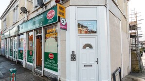 A storefront with a green sign advertising 'Best-in Value' for fruit & vegetables, a 'Payzone' sign, and a 'Sunnyside Apartments' window. - Contractor*Long Stays Discounts*Parking (Bristol)