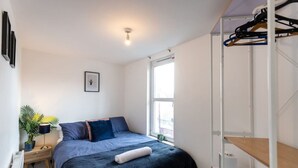 A bedroom with a bed, a bedside table with a lamp, a window, and a wardrobe. - Contractor*Long Stays Discounts*Parking (Bristol)