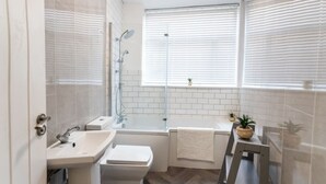 Un baño moderno con ducha, bañera y lavamanos.