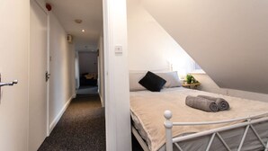 A bedroom with a bed, a nightstand, and a window. - Contractor*Long Stays Discounts*Parking (Bristol)