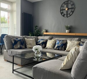 Relax in this stylish living room with a grey sofa, glass coffee table, and elegant vase.