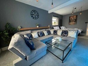 Relax in this stylish living room with a comfortable sectional sofa and a glass coffee table.