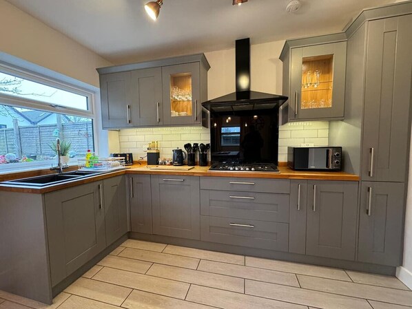 Enjoy cooking in this well-equipped kitchen with a central island, range hood, and tiled backsplash.