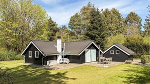 A cabin with a large deck, a dining area, and a separate building with a chimney. - Amazing home in Ansager with WiFi (Ansager)
