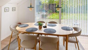 A round wooden dining table with six chairs, a small plant, and a candle on the table. - Amazing home in Ansager with WiFi (Ansager)