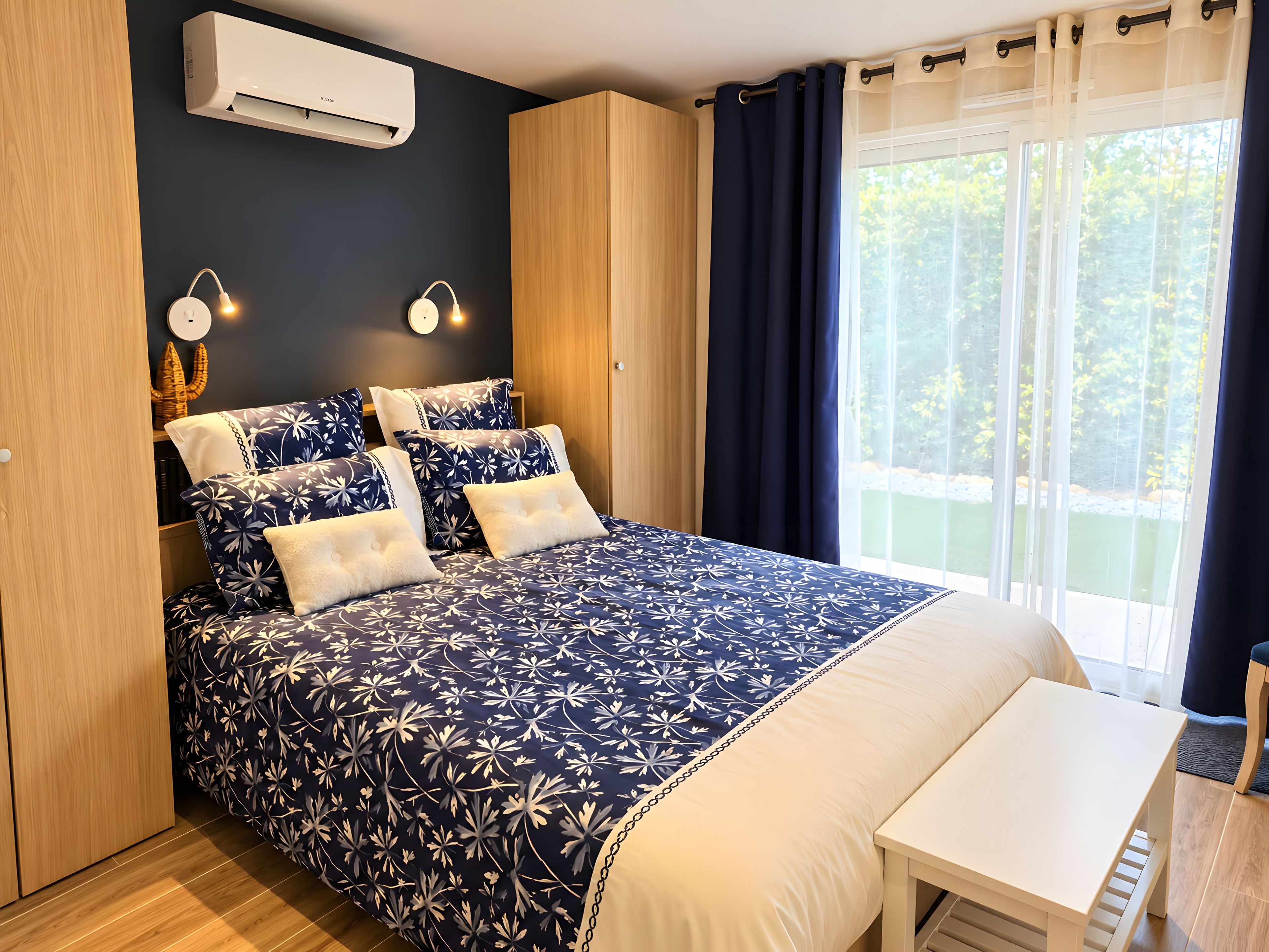Une chambre dotée d’un grand lit, de lampes de chevet, d’un climatiseur et offrant une vue sur la verdure environnante.