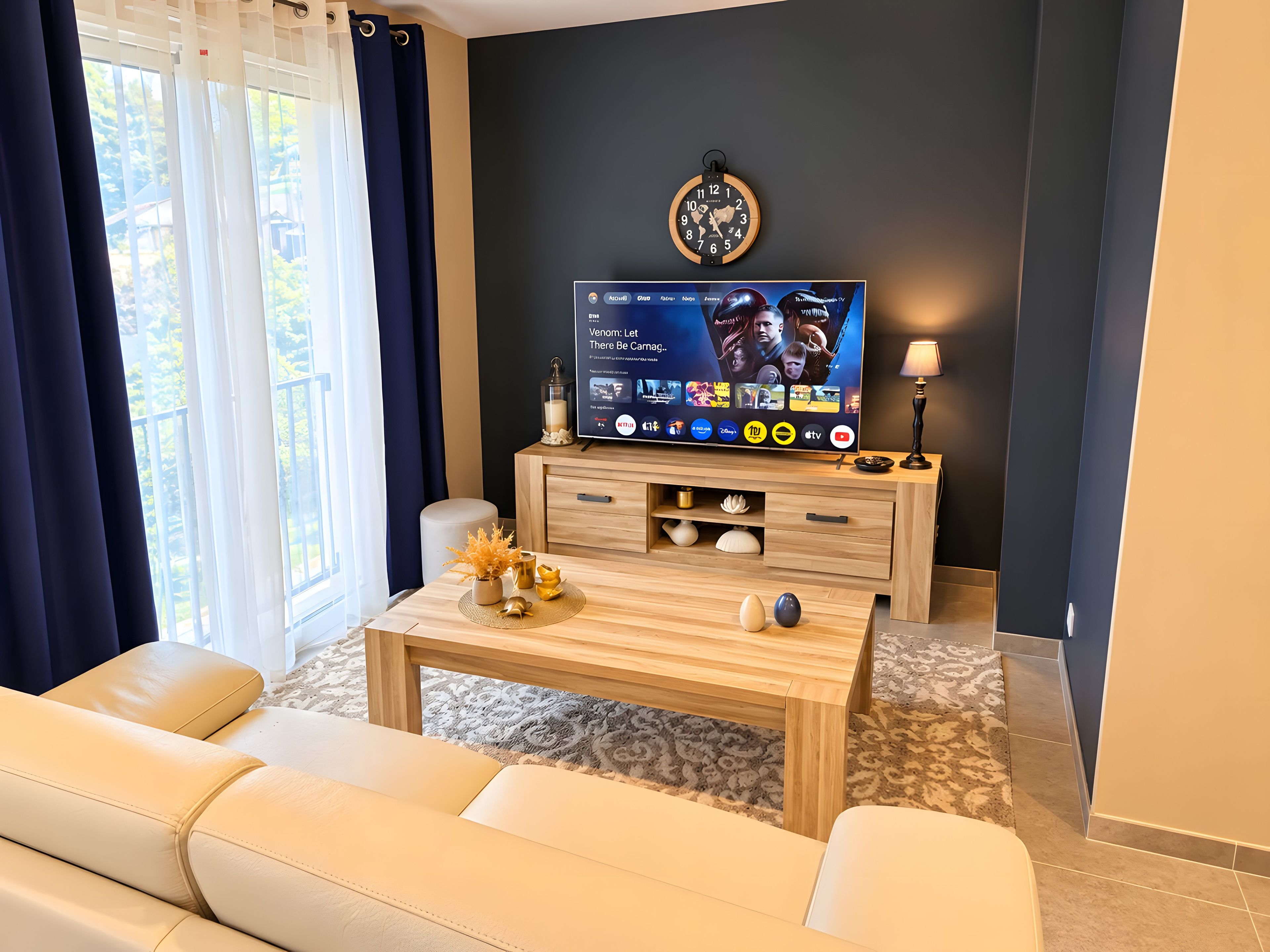 A modern living room with a flat-screen TV, a sofa, a coffee table, and a decorative wall clock.