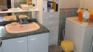 A bathroom with a sink, mirror, and toiletries.