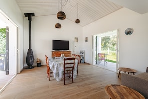 A modern living room with a fireplace, dining table, and seating area.