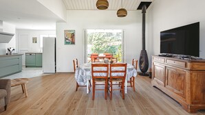 Une cuisine moderne avec des meubles en bois, une table à manger avec des chaises et une grande fenêtre.