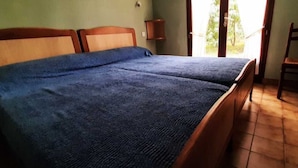 A bed with a dark blue cover, wooden headboard, and a nightstand with a lamp. - Holiday Home 'Maison À 8min De Plage Giraudière' with Private Terrace and Private Garden (Le Grand-Village-Plage)