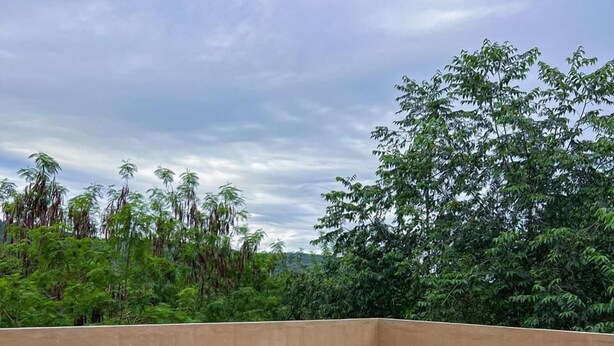 An outdoor dining area with tables and chairs, surrounded by lush greenery and a clear sky. - Pousada Sempre Viva Lençóis (Lençóis)