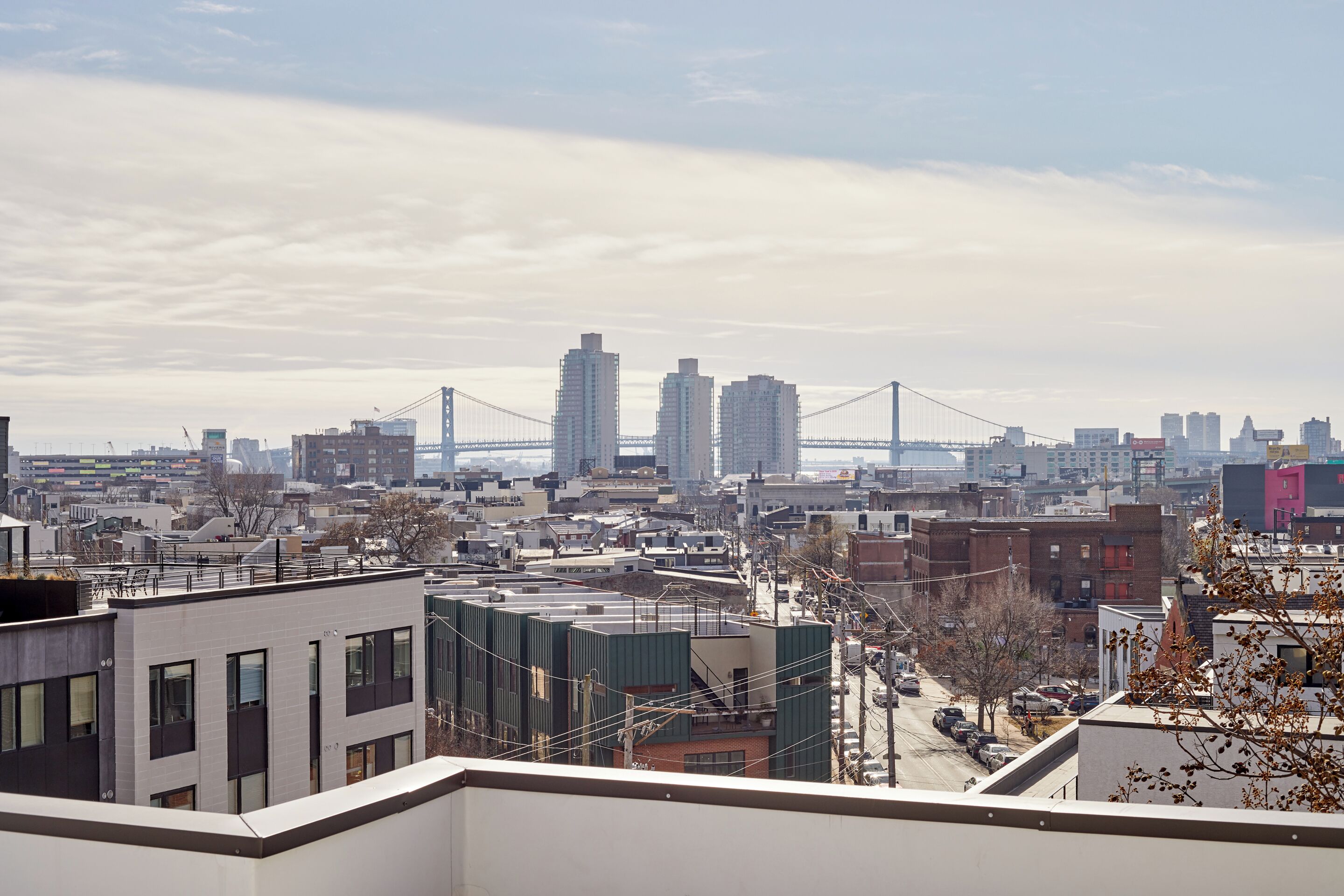 Une vue urbaine avec des bâtiments modernes, un pont imposant et un ciel dégagé.