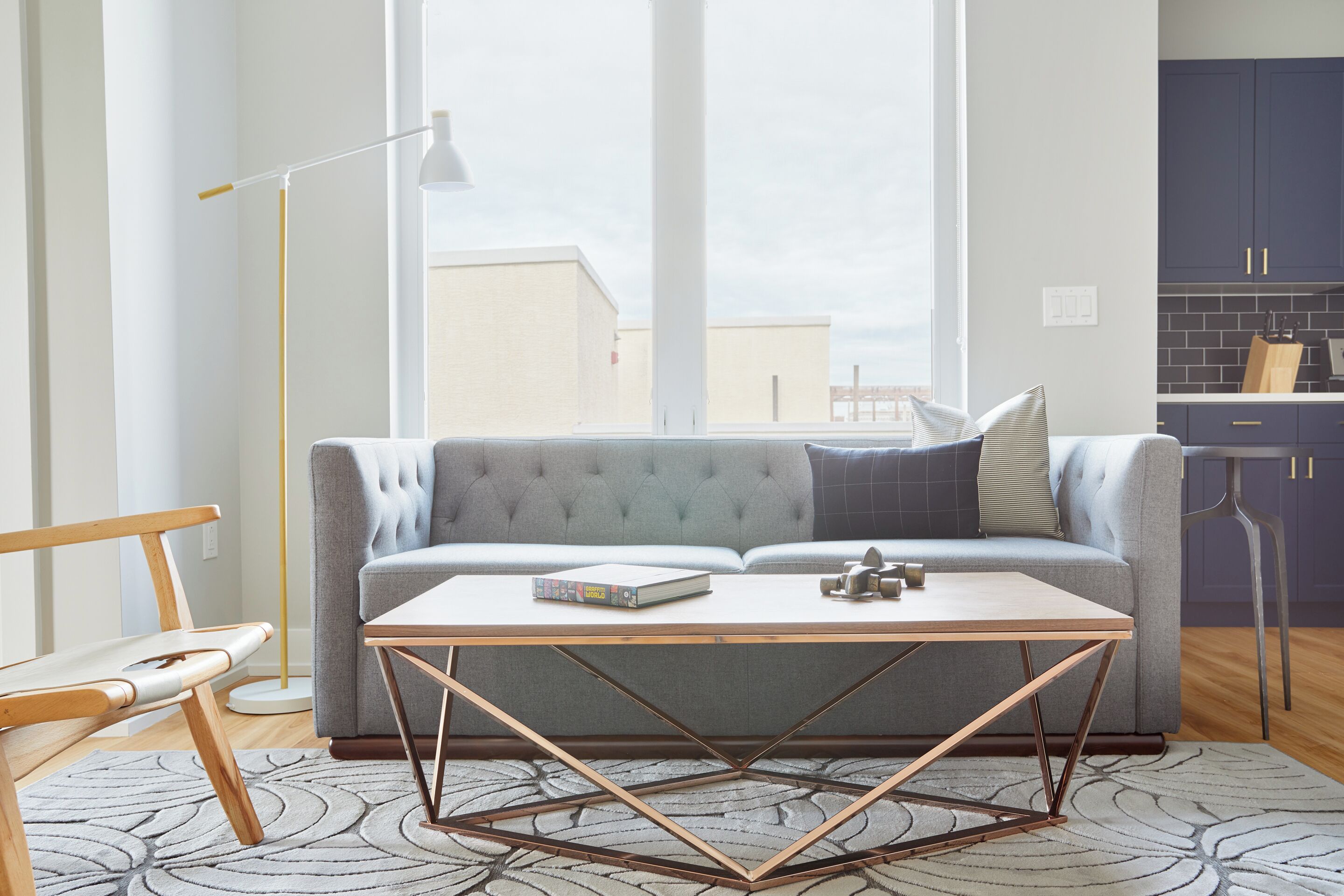 A modern living room with a grey sofa, a wooden coffee table, and a floor lamp.