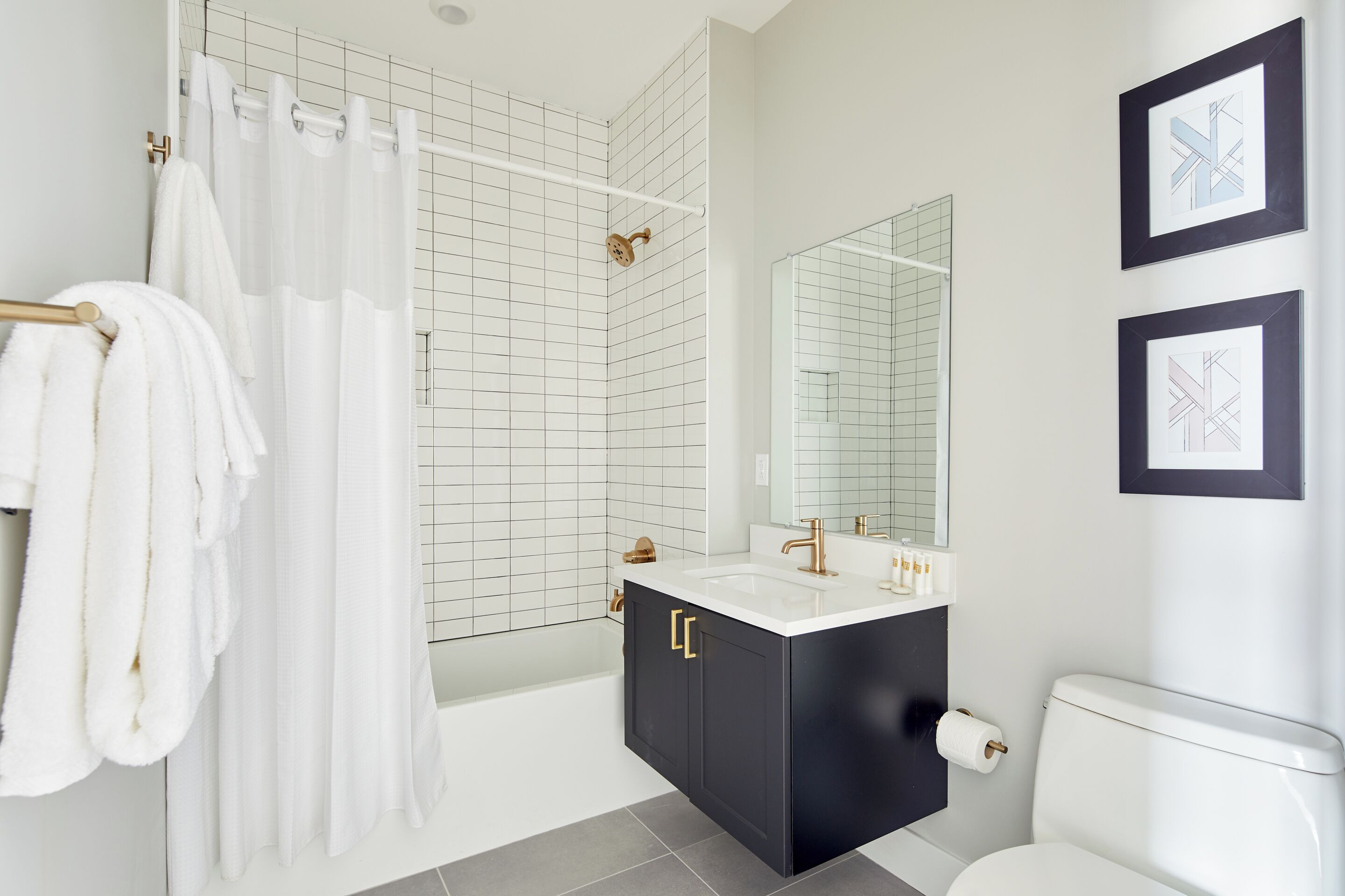 Une salle de bain moderne avec une baignoire, un grand miroir et des toilettes.