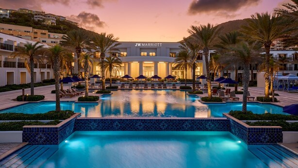 A JW Marriott hotel with a large pool surrounded by palm trees and lounge chairs. -  
Perfect 3 bedroom family villa ,beach front view 2 minutes walk to the beach (Upper Prince's Quarter)
