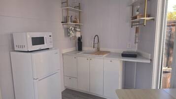 Fridge, microwave, coffee/tea maker, cookware/dishes/utensils