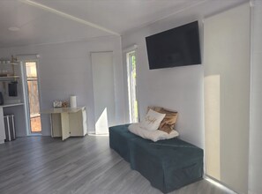 Una habitación moderna con cama, televisión y kitchenette.