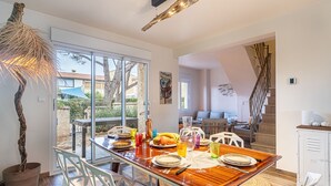 A dining area with a glass table, white chairs, and a view of the outdoors. - Le Rayolet Parc by Interhome (Six Fours)