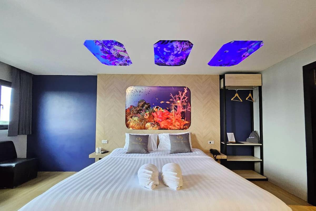 Une chambre d’hôtel moderne avec un grand lit, une table de chevet, un bureau et une armoire.