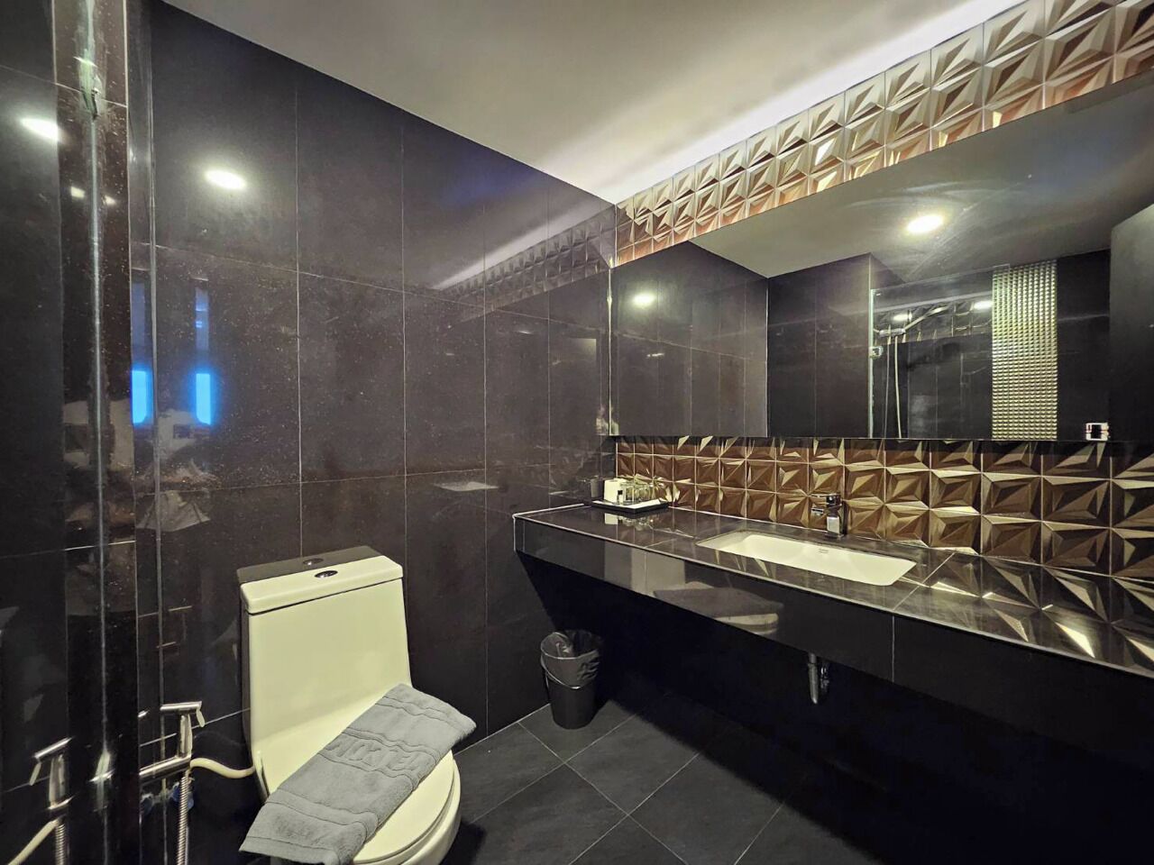 A modern bathroom with a toilet, sink, and mirror.