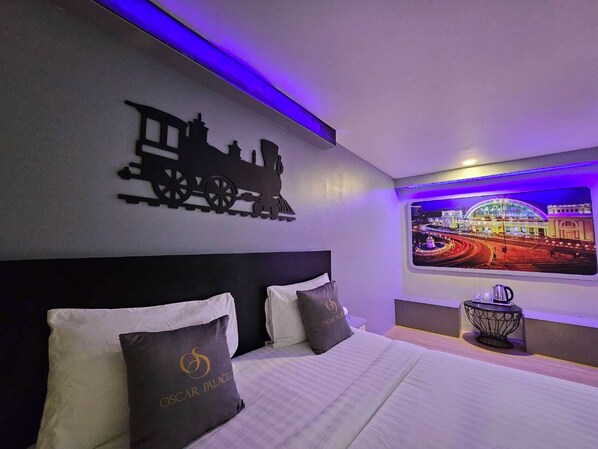 Una habitación de hotel con cama, televisor montado en la pared y un adorno decorativo.