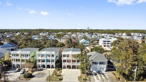 A coastal residential area with multiple two-story houses, some with balconies, and a clear view of the ocean.