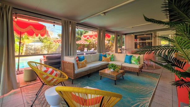A spacious living area with a large sofa set, a coffee table, and wicker chairs. - Beach Oasis: Hot tub, Pool, Mini-golf, Game Room (Seminole)