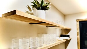 Una estantería con una planta en maceta y varios recipientes de vidrio.