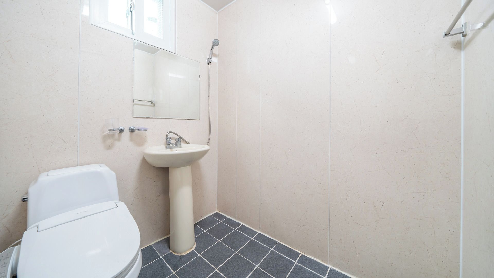 Un baño con inodoro, lavabo y ducha.