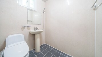 Un baño con inodoro, lavabo y ducha.