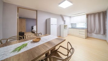 Un apartamento pequeño con comedor, kitchenette y un dormitorio.