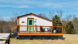 Una petita cabana amb un porxo, una porta verda i el número 7898 al costat.
