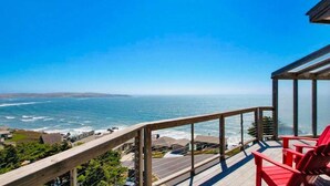 Een balkon met uitzicht op de oceaan en een houten leuning.