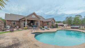 A house with a swimming pool, patio furniture, and a barbecue grill.
