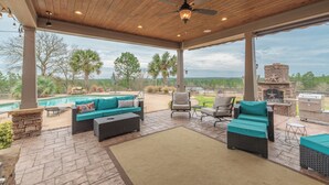An outdoor patio with a pool, seating area, and barbecue grill.