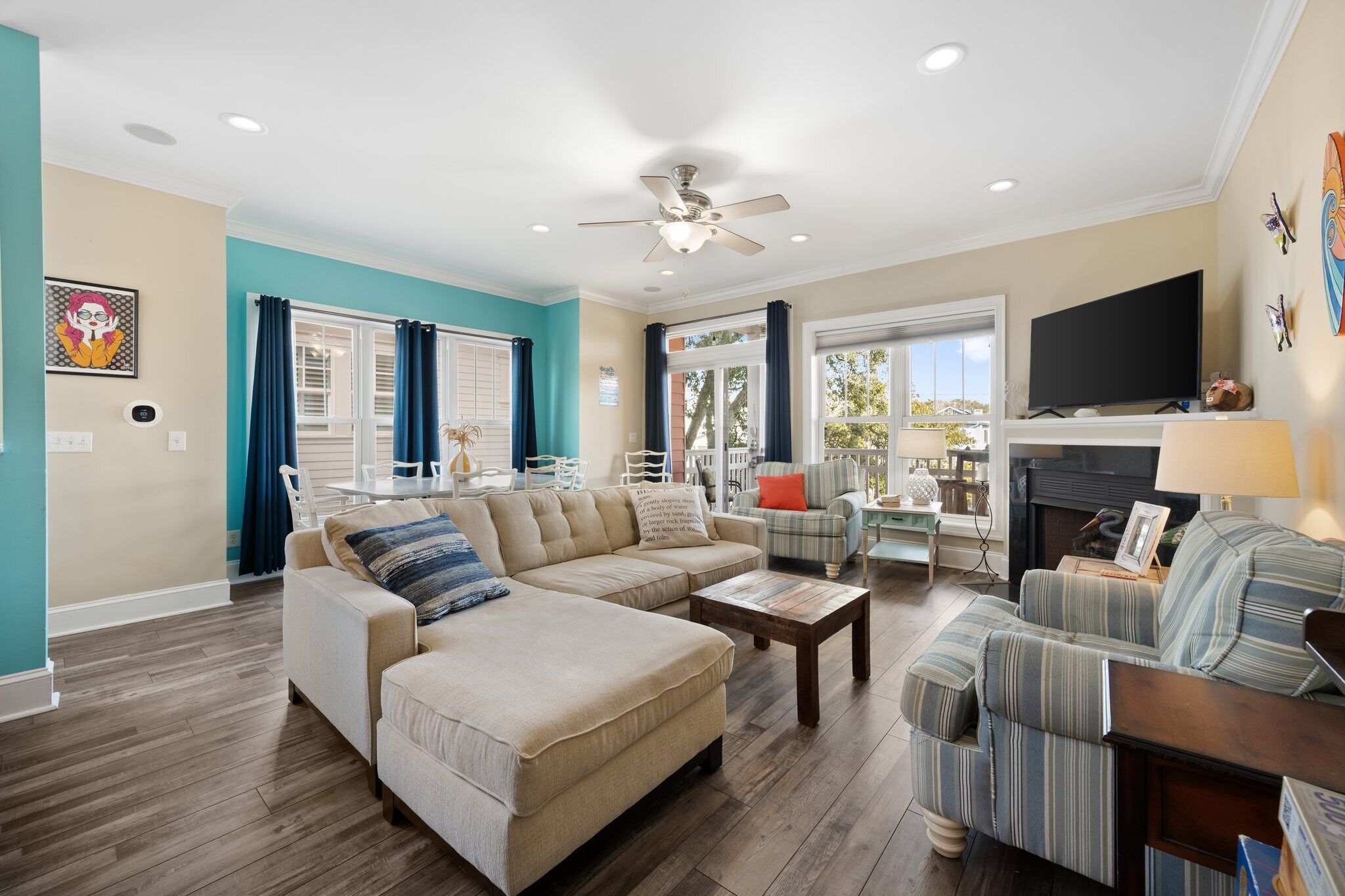 A living room with a sectional sofa, a coffee table, a TV, and a fireplace.