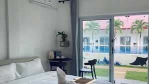 Een hotelkamer met een groot bed, een bureau, een stoel en uitzicht.