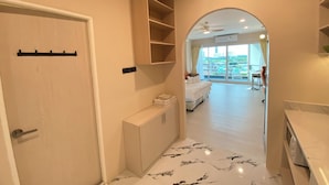 A hotel room with a bed, a bathroom, a balcony, and a view of the city. - Studio View Talay (Pattaya)