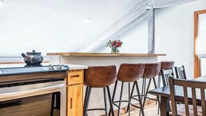 Una cocina moderna con encimera de madera, taburetes de bar y vistas al exterior.