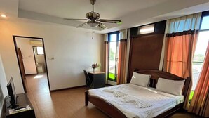 A spacious bedroom with a large bed, a desk, and a ceiling fan. - Tamnak Lanta at Chiang Mai (Chiang Mai)