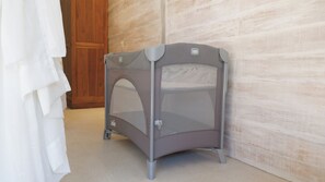 Une cage de transport pour animaux de compagnie, de modèle portable, se trouve dans une pièce dotée d’une porte en bois et d’un mur à texture.